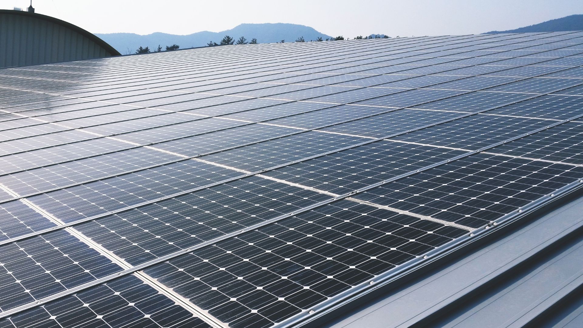 solar panels on a roof with hills in the background