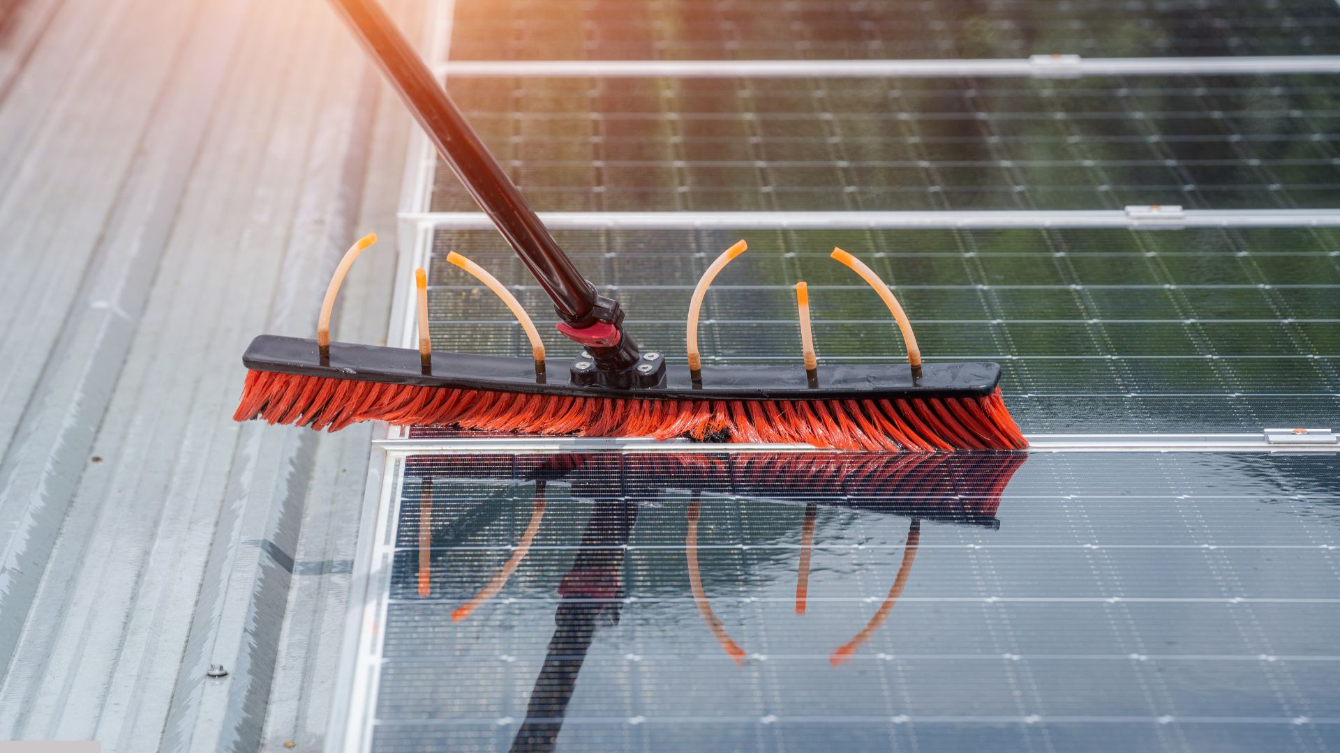 Close-up of a red cleaning brush on a long handle