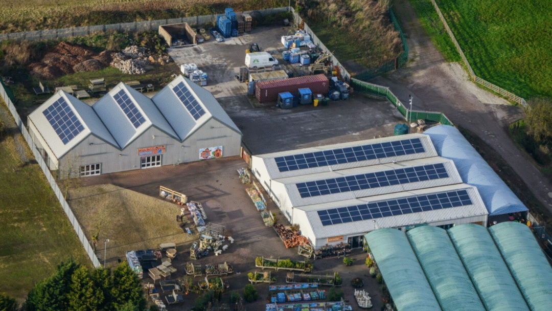 Aerial view of multiple commercial buildings with rooftop solar panel systems.