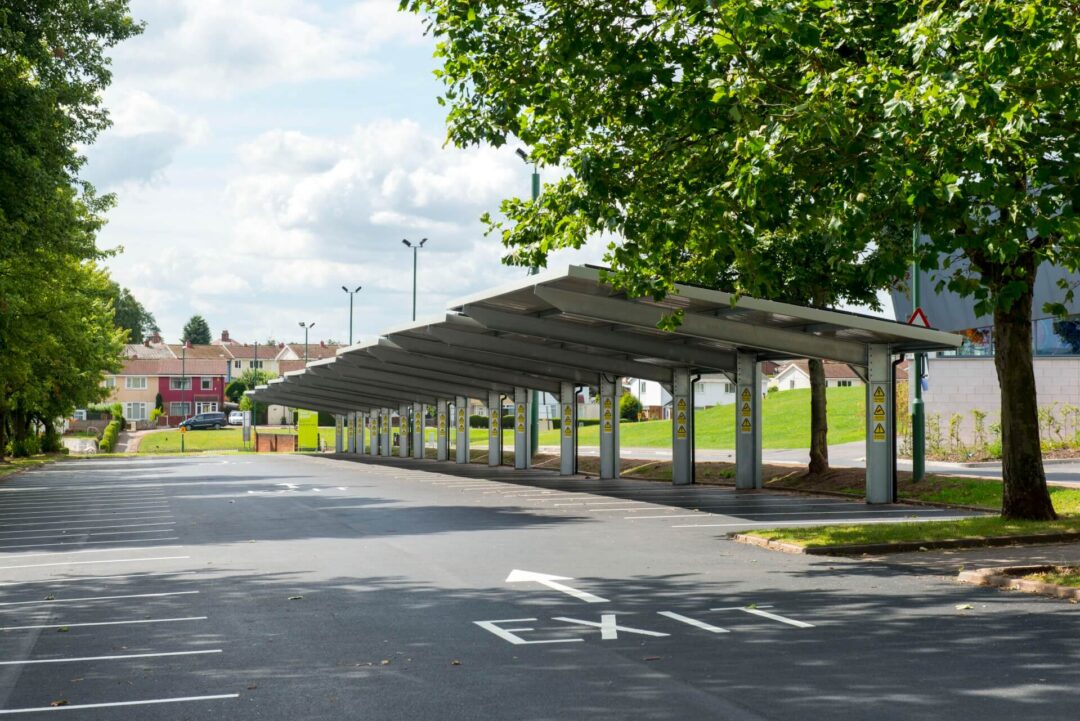 Long solar canopy structure shading an empty commercial parking area, demonstrating sustainable infrastructure for vehicles and potential charging in Solar Carports