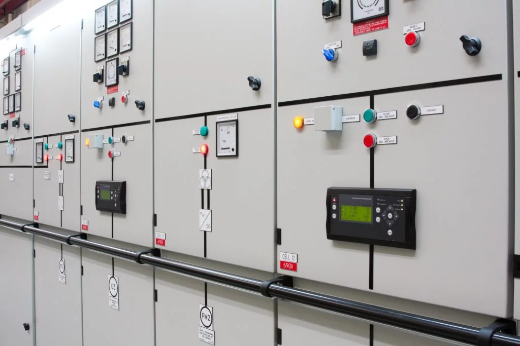 High-voltage electrical switchgear panel with control buttons, indicators, and monitoring displays inside an industrial power distribution room in services.