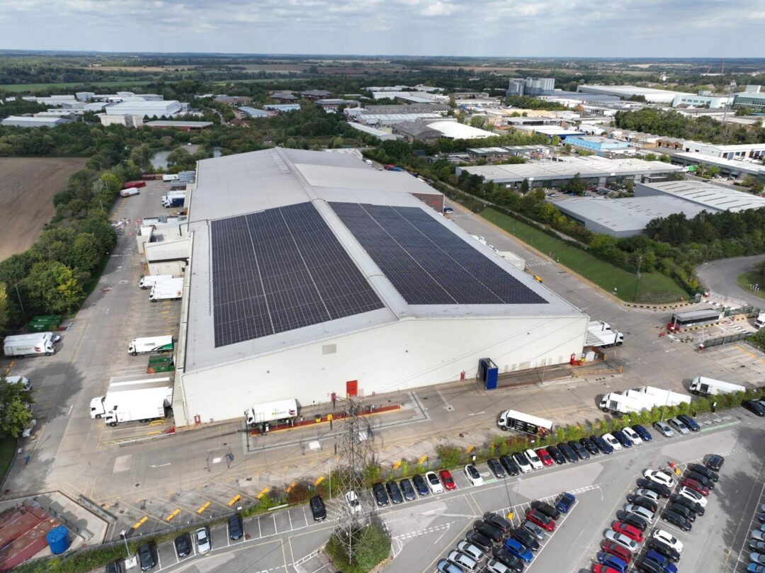 Solar panels crowning the roof of a commercial building for food production