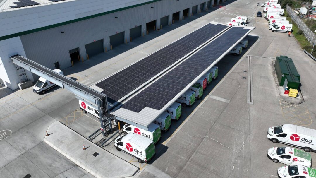 Aerial view of a DPD distribution centre featuring a solar-powered carport with integrated EV charging for electric delivery vans, supporting zero-emission logistics in DPD Docklands.