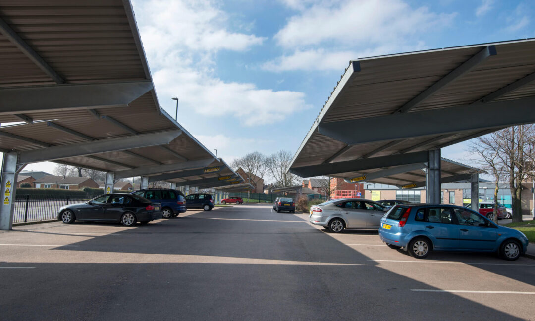 Solar carport sheltering a car in a parking lot