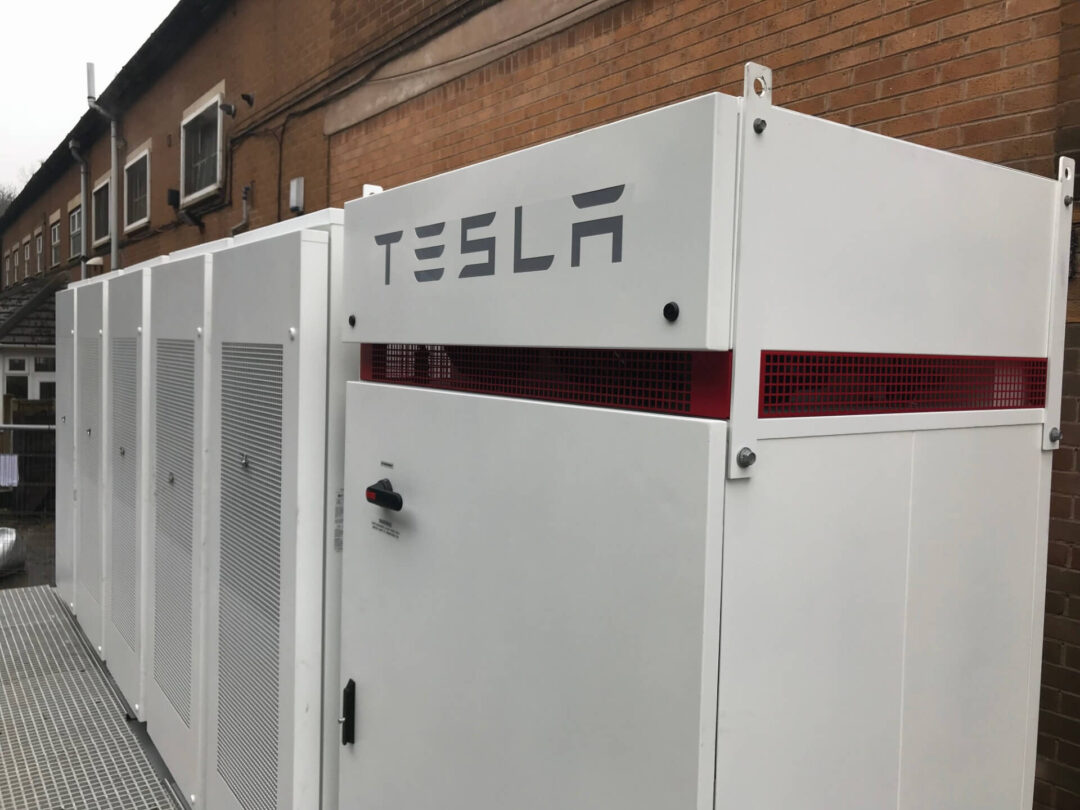 tesla megapack next to brick wall outside